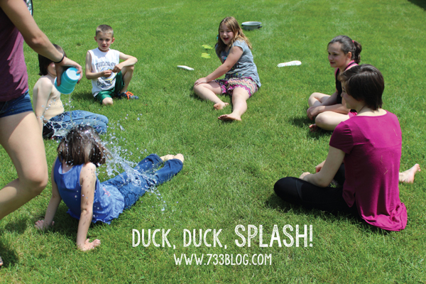 Kids sitting on the grass playing duck, duck, splash
