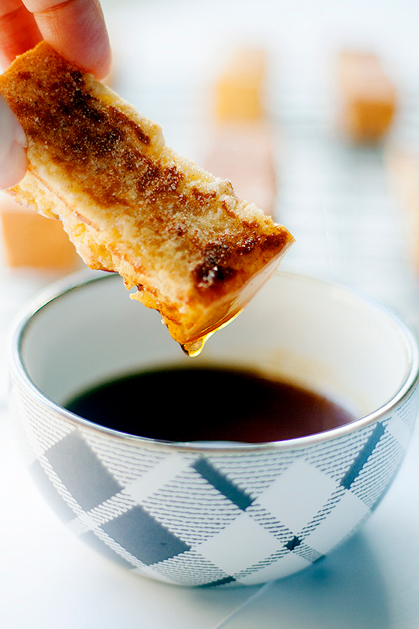Make ahead french toast stick being dipped into syrup