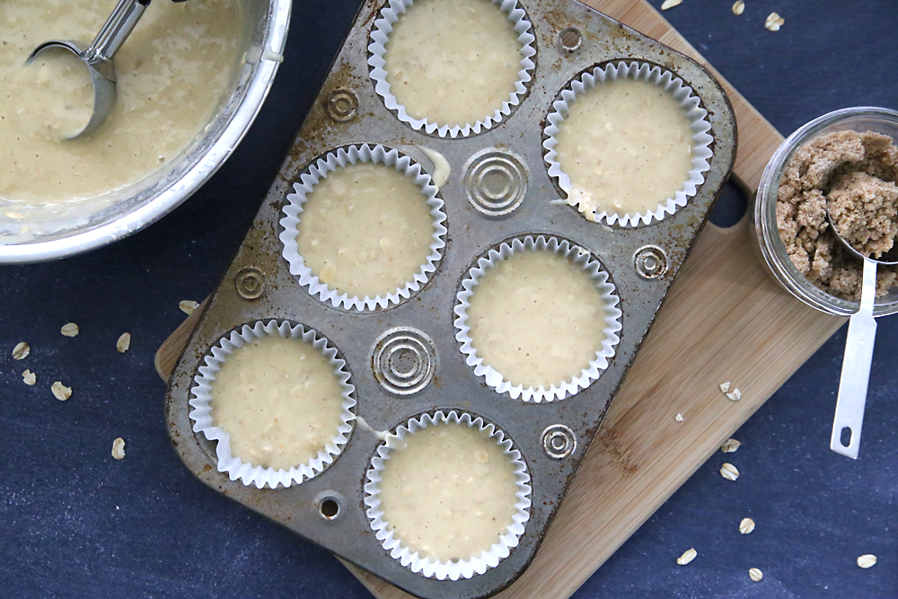 A muffin tin filled with oatmeal muffin batter