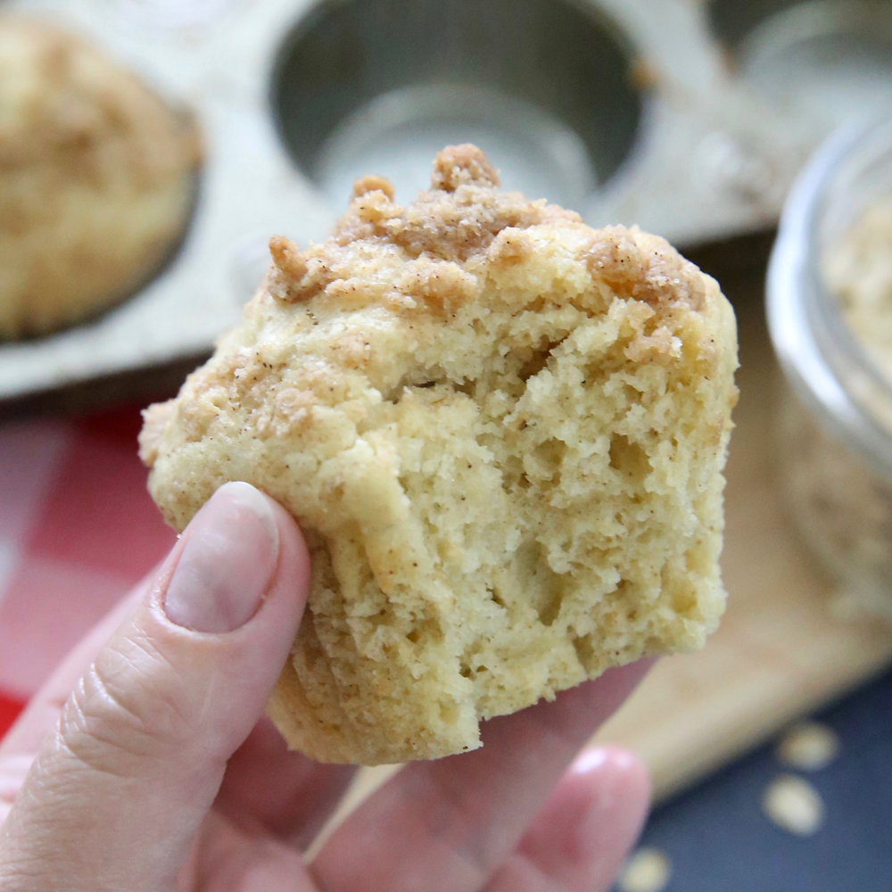 Hand holding an instant oatmeal muffin with a bite taken out of it