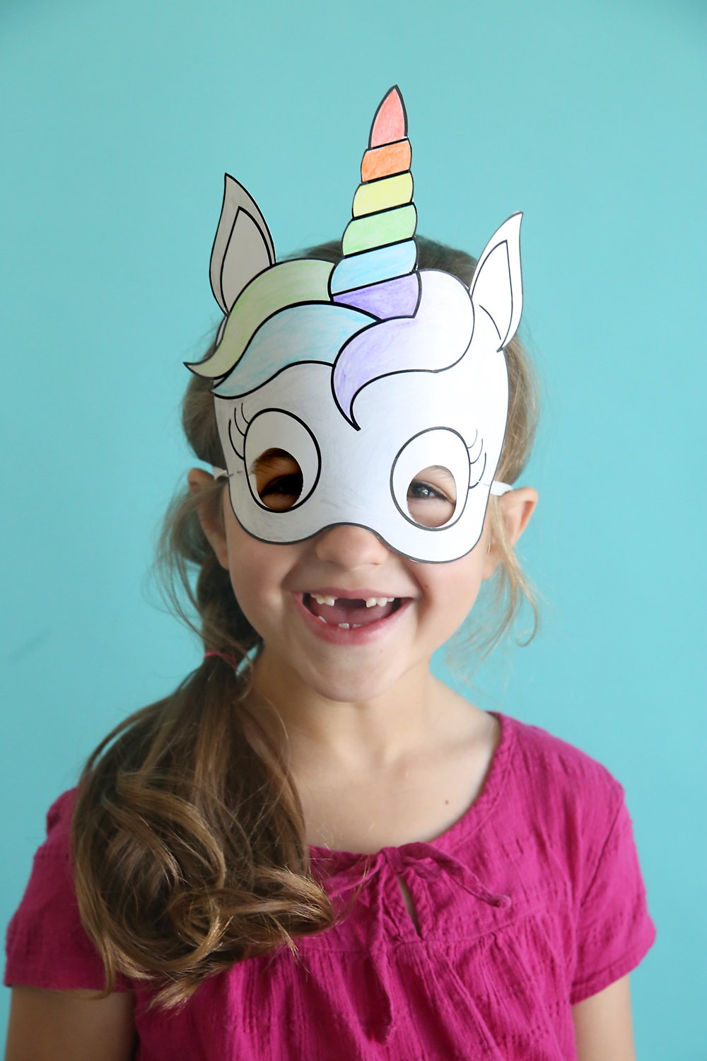 A girl wearing a unicorn mask