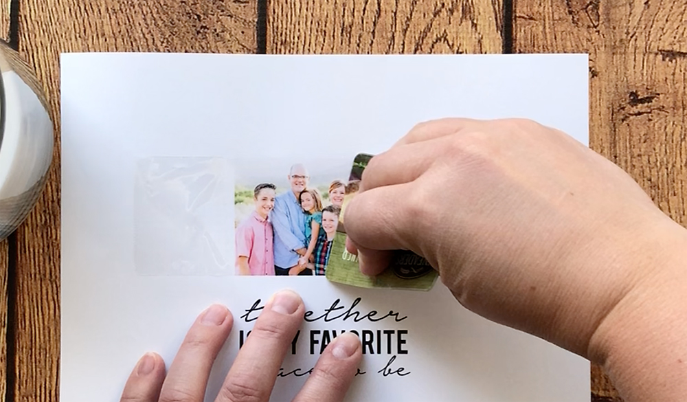 Hands using credit card to smooth down packing tape