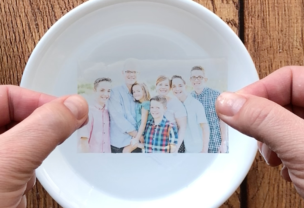 Hands holding the tape which has the photo transferred onto it