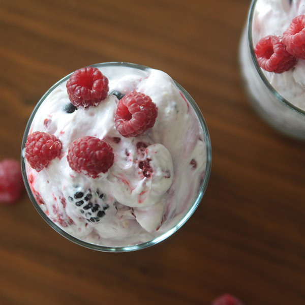 Berry cheesecake fluff in a class on top of a wood table