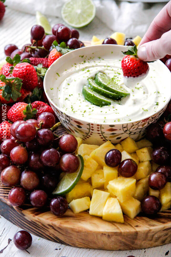 Grapes, pineapple and other fruit on a plate, with a bowl of fruit dip