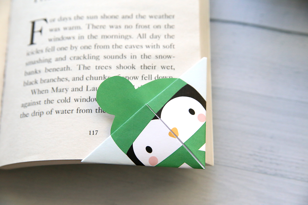 Penguin corner bookmark on a book
