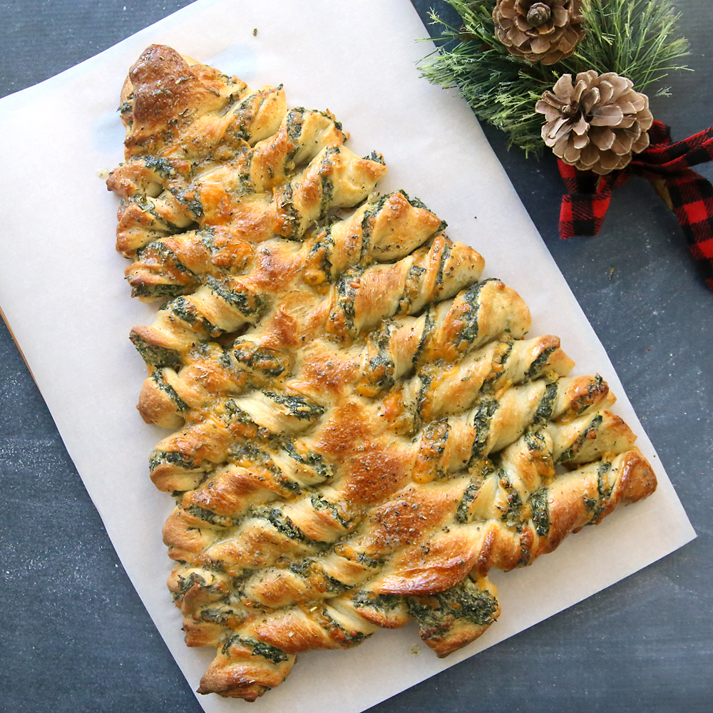Breadsticks in the shape of a Christmas tree filled with spinach dip