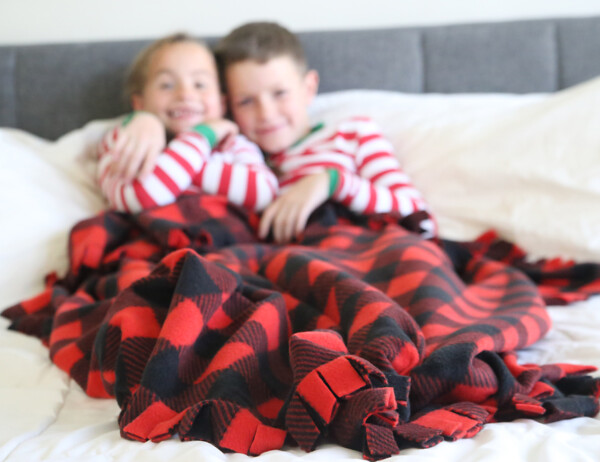 Brother and sister with a DIY fringed fleece blanket