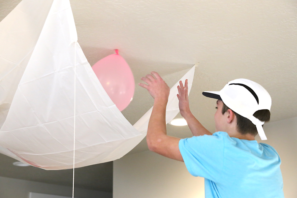 Boy filling the tarp with balloons