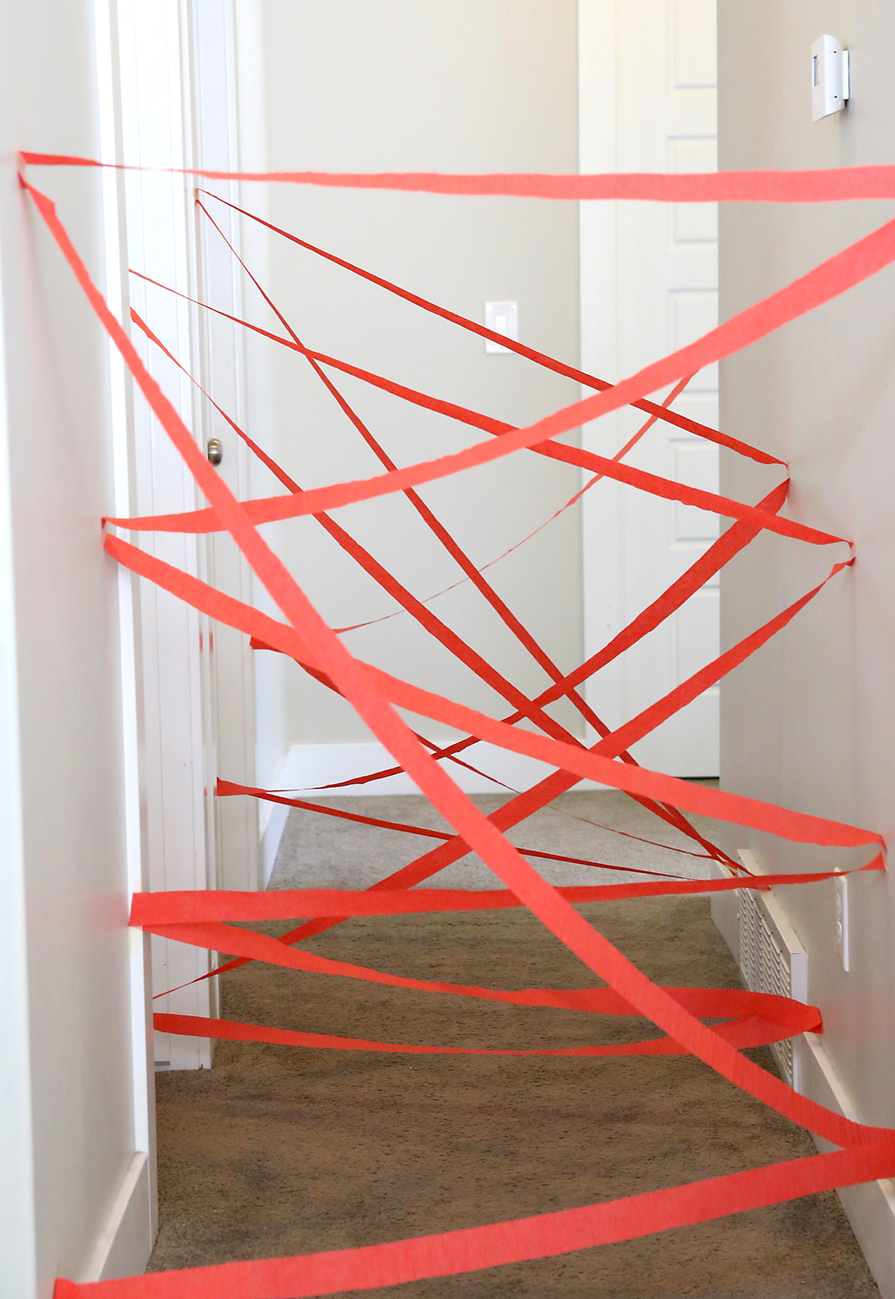 Make a hallway laser maze! Easy, inexpensive indoor activity for kids that's super fun! Perfect for kids who love playing superhero or spy - and fun for birthday parties, too.
