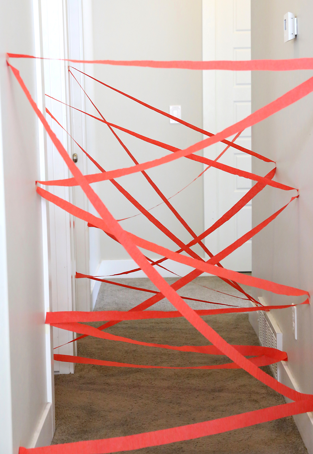 A hallway with red crepe paper strips cross crossing it