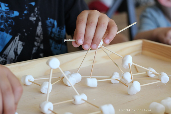 Child using marshmallows and toothpicks to build