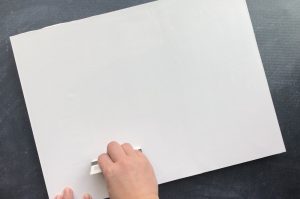 Hand using credit card to smooth photo down