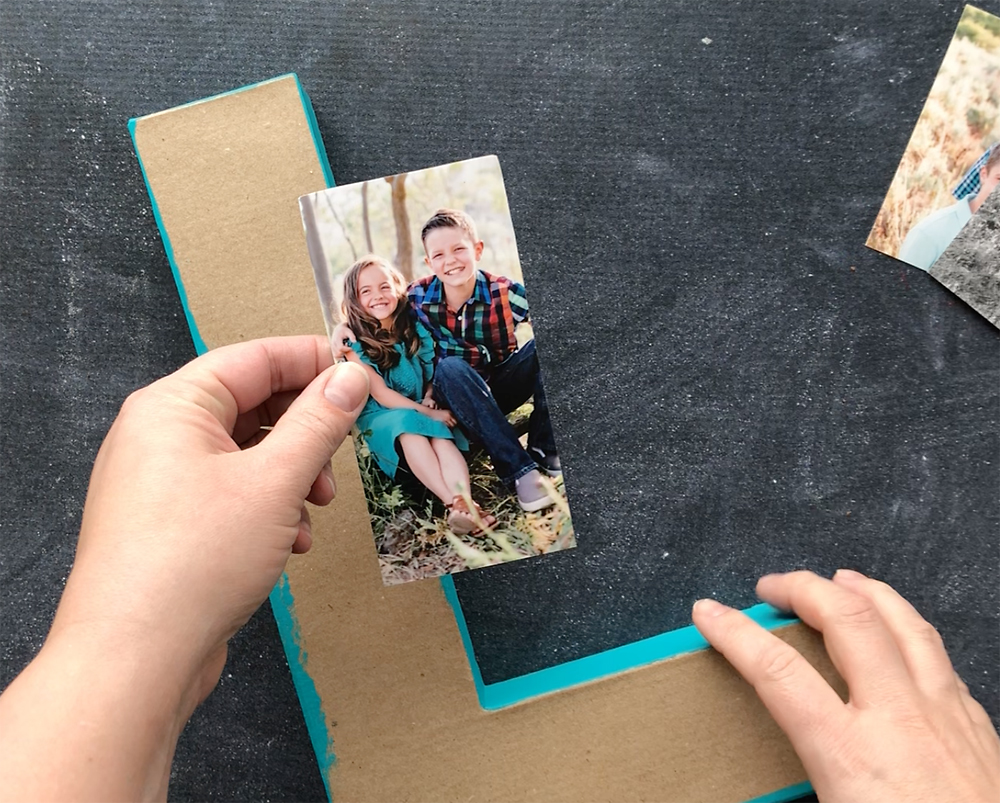 Hand holding large paper mache letter and photo that has been trimmed to fit