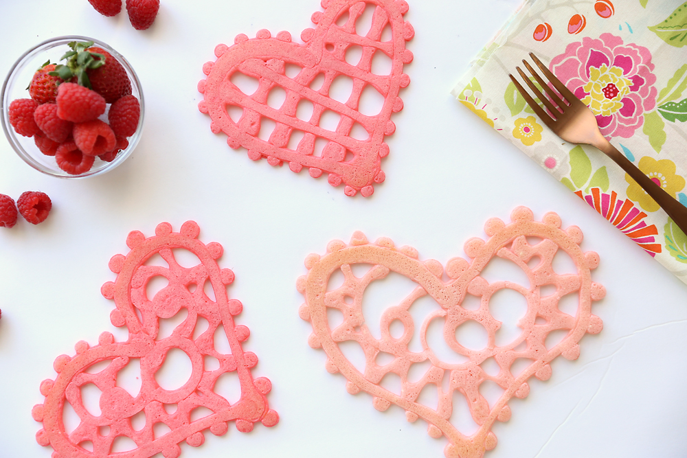 Pink pancakes in the shape of hearts that look like lace