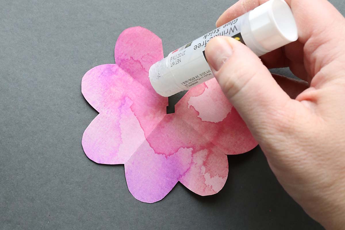 Putting glue on cut edge of petal