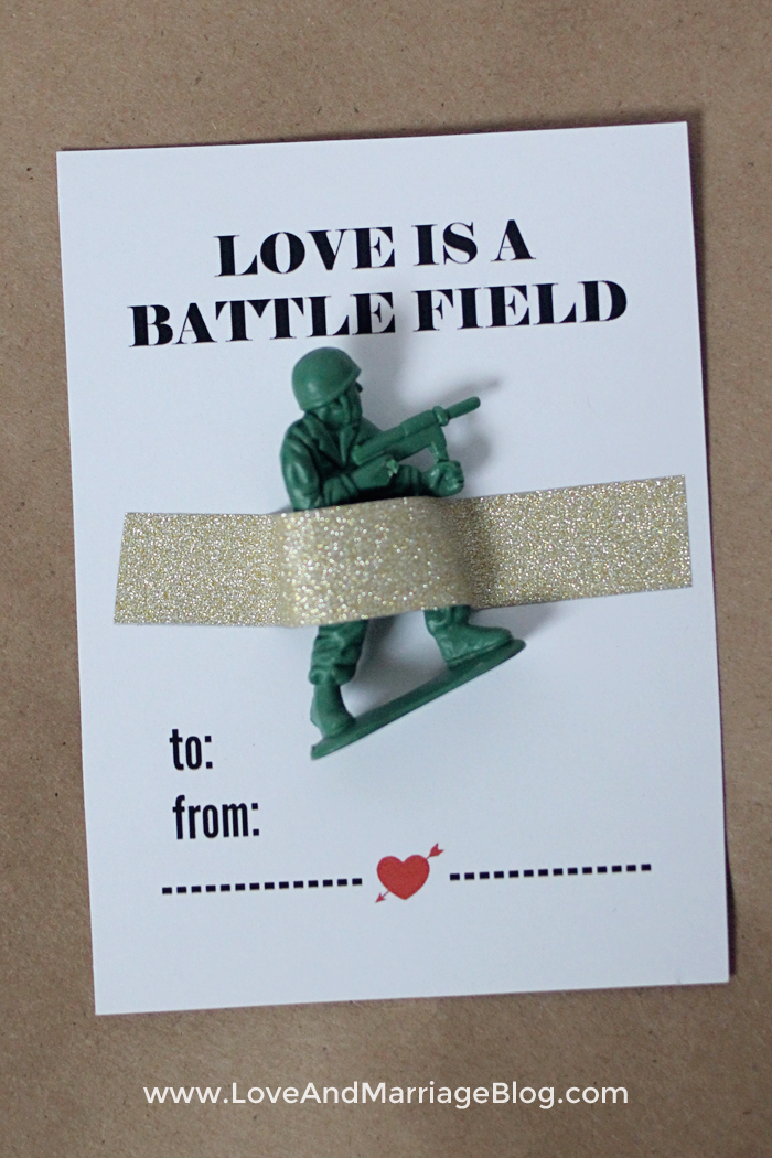 Valentines Day card that says Love is a Battlefield with green army man taped on top