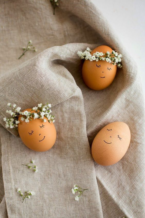 Brown Easter eggs with cute faces drawn on them and flower crowns