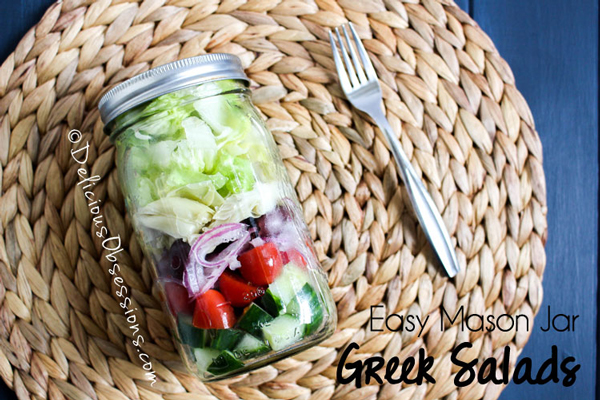 Greek salad ingredients layered in a mason jar