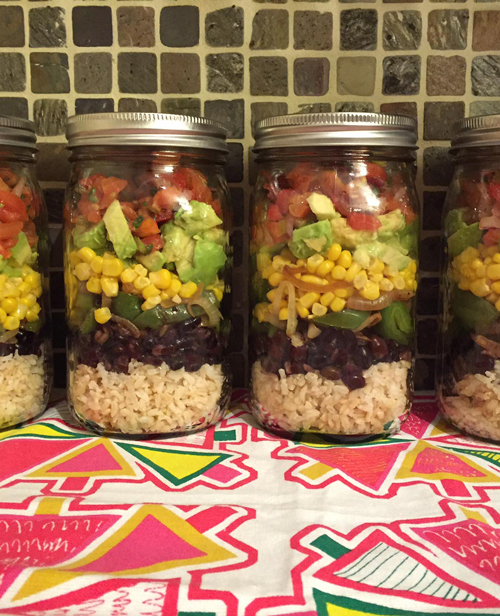 Mexican burrito bowl ingredients layered in mason juars