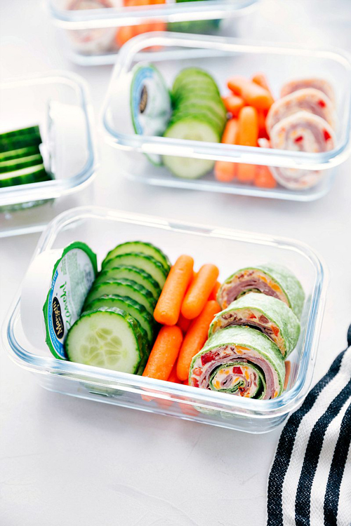 Ham and cheddar pinwheels with baby carrots and cucumber slices