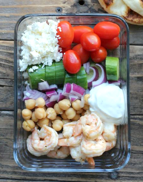 Greek shrimp meal prep bowl with vegetables, feta cheese and yogurt sauce