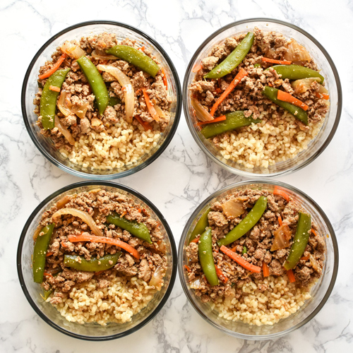 Turkey snap pea stir fry with vegetables and rice divided into meal prep containers