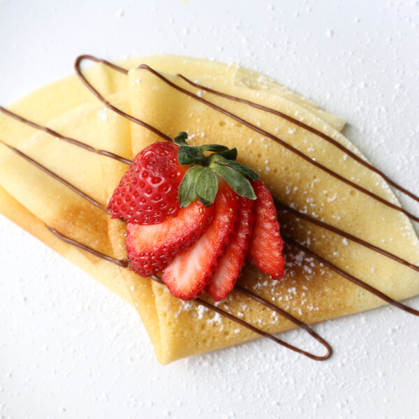 Homemade crepes with chocolate drizzle and strawberry