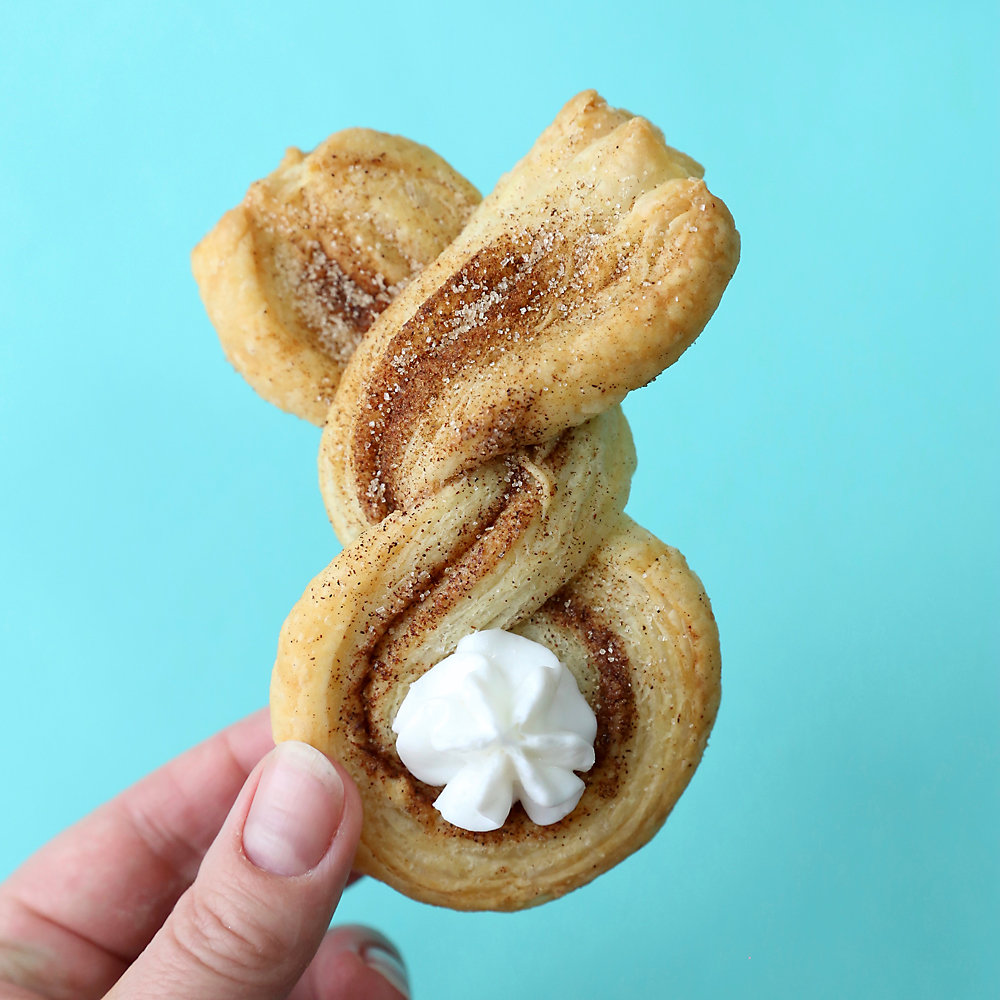 Hand holding a cinnamon sugar puff pastry bunny