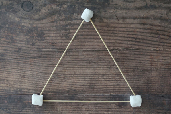 Three wood skewers connected in a triangle by marshmallows