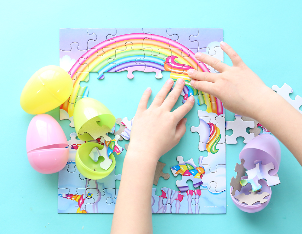 Kids hands putting together puzzle with pieces from plastic Easter eggs