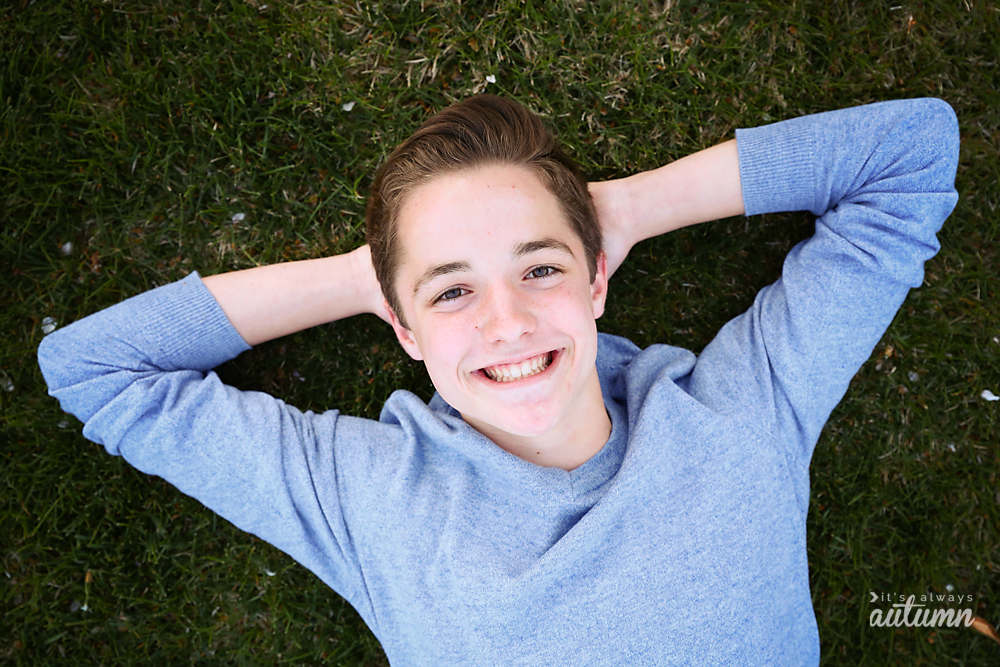 Photo pose: boy laying on the grass with his hand behind his head