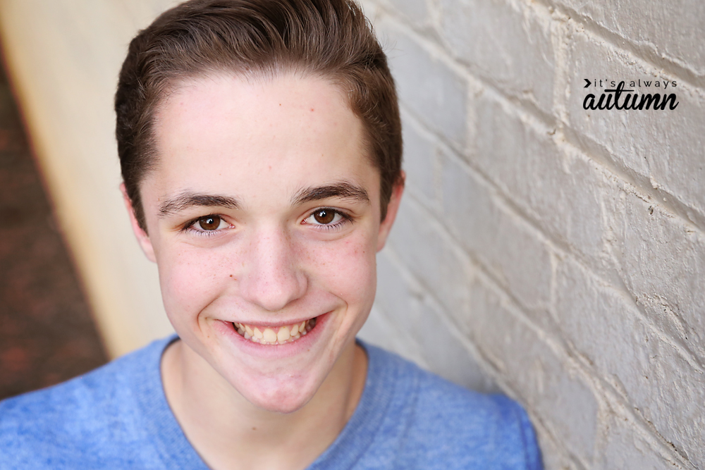 A closeup of a boy smiling with blurred background