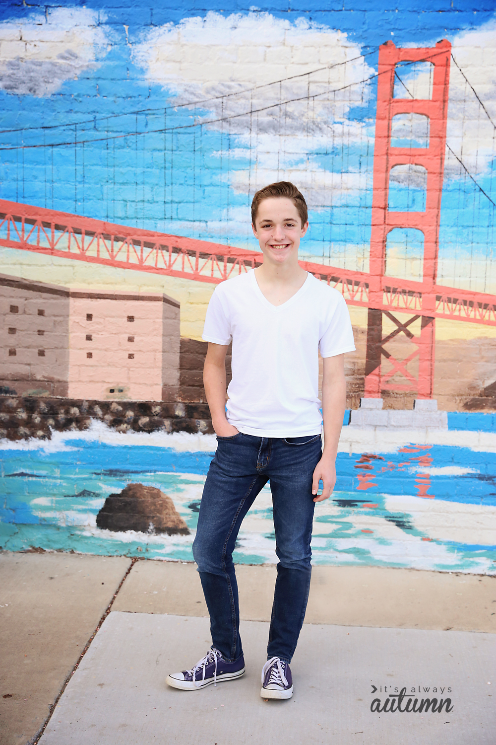 A boy standing in front of a wall mural