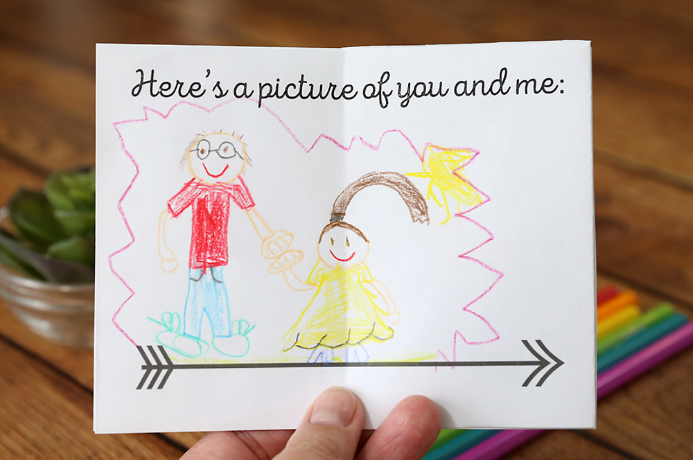 LIttle paper Father\'s Day book with page that says Here\'s a picture of you and me: and kids\' drawing
