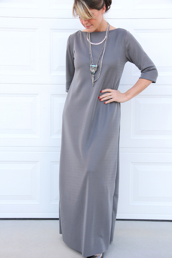 Woman wearing a long grey dress with 3/4 length sleeves