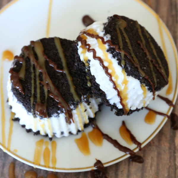 Two Oreo ice cream sandwiches on a plate with caramel and hot fudge