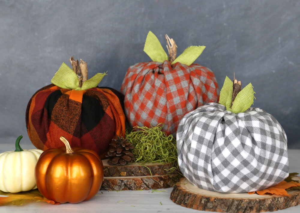 Pumpkin made from a roll of toilet paper wrapped with flannel fabric with a stick for the stem and ribbon tied around for leaves