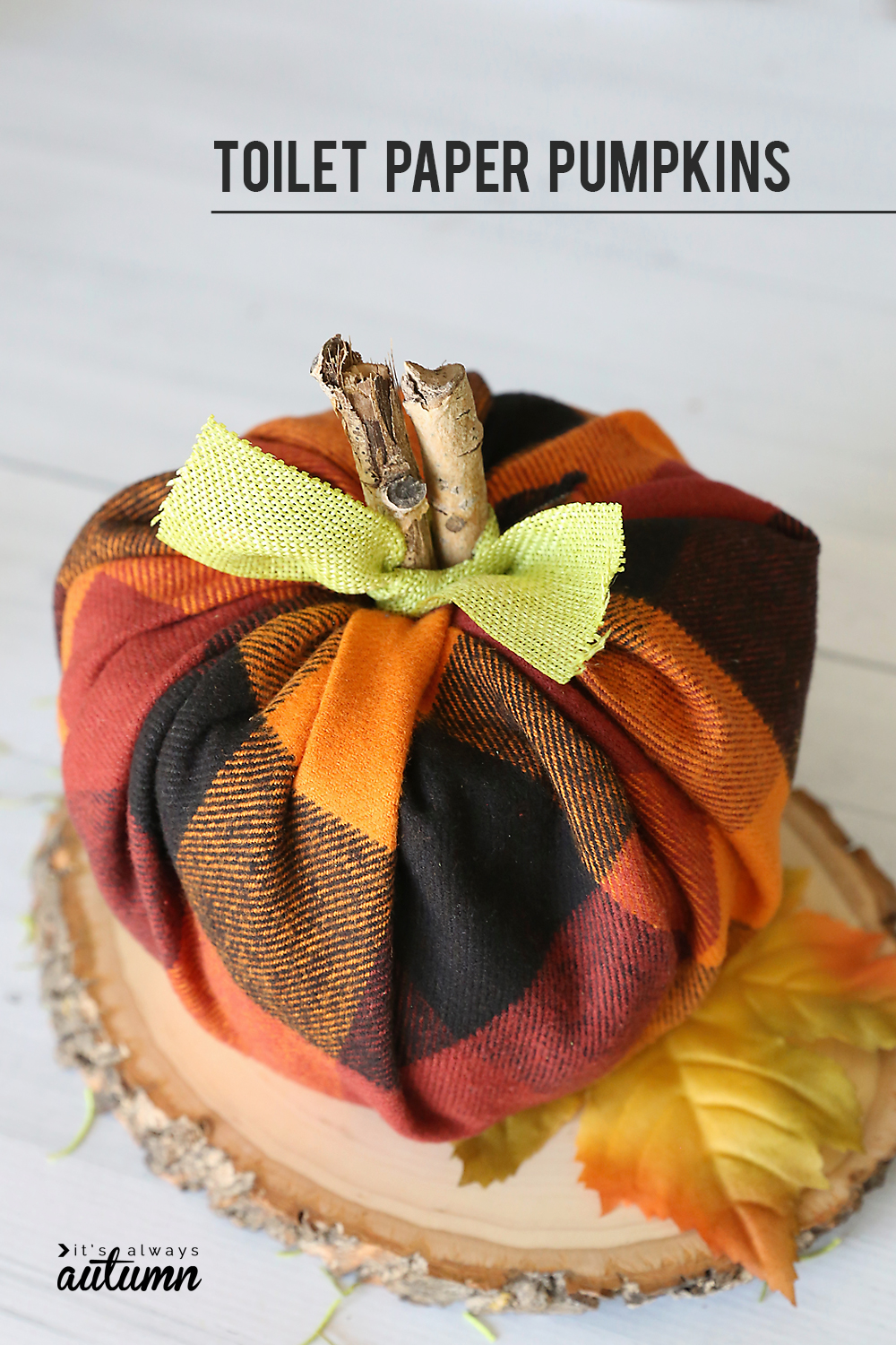 Pumpkin made from a roll of toilet paper wrapped with flannel fabric with a stick for the stem and ribbon tied around for leaves