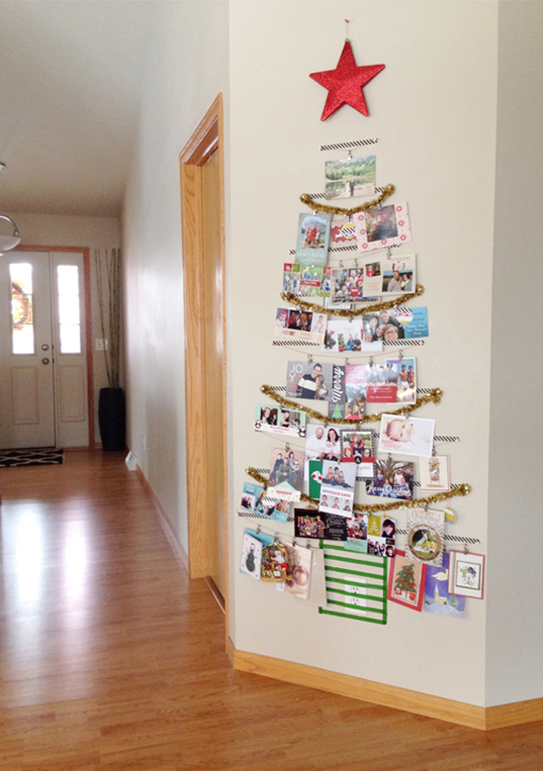 Christmas cards hung up on a wall in the shape of a Christmas tree