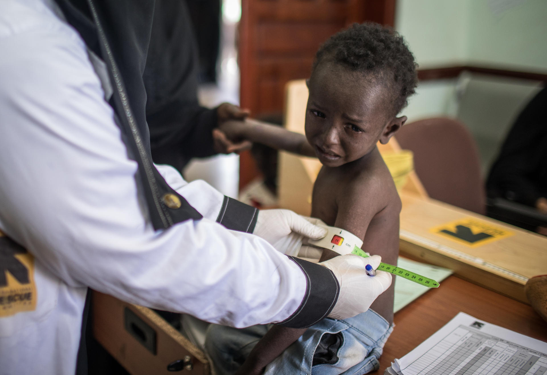 Nurse measuring the size of a young boy\'s arm