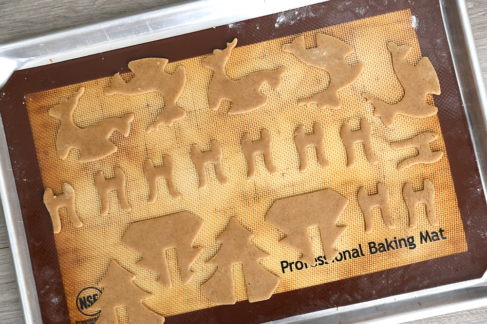 3D gingerbread cookie dough pieces on a baking sheet