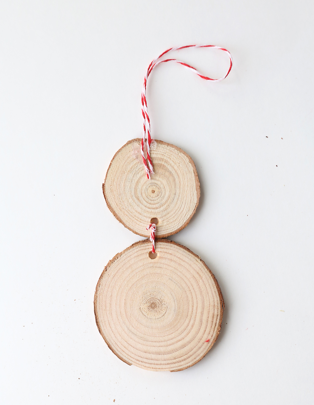 Two wood slices tied together with a loop of twine at the top