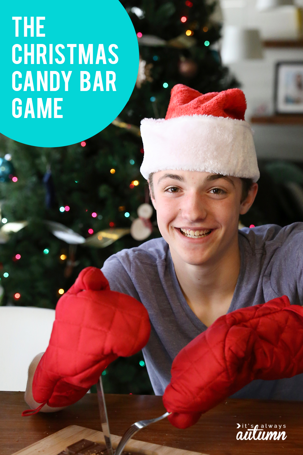 Boy in Santa hat and wearing red oven mitts cutting a large candy bar