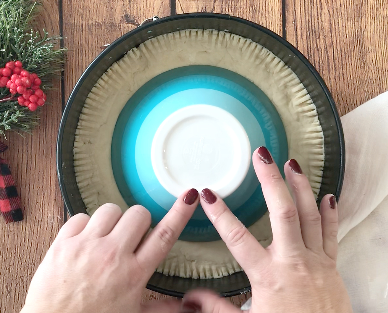 Hands pressing a bowl down into the shortbread dough to create a circle on the dough