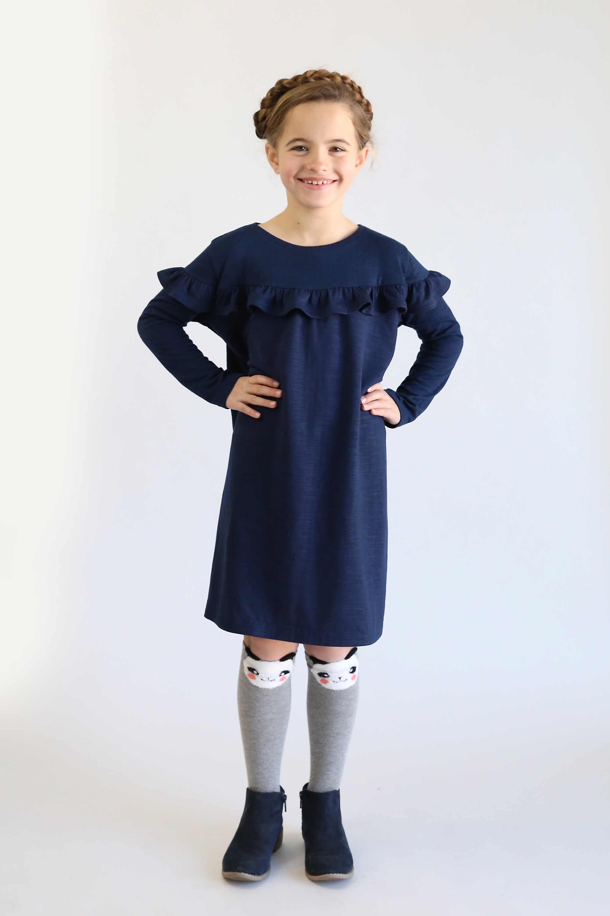 Girl wearing a dress with a ruffle around the chest and shoulders