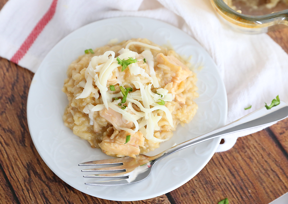 Chicken and rice casserole topped with cheese on a plate with a fork