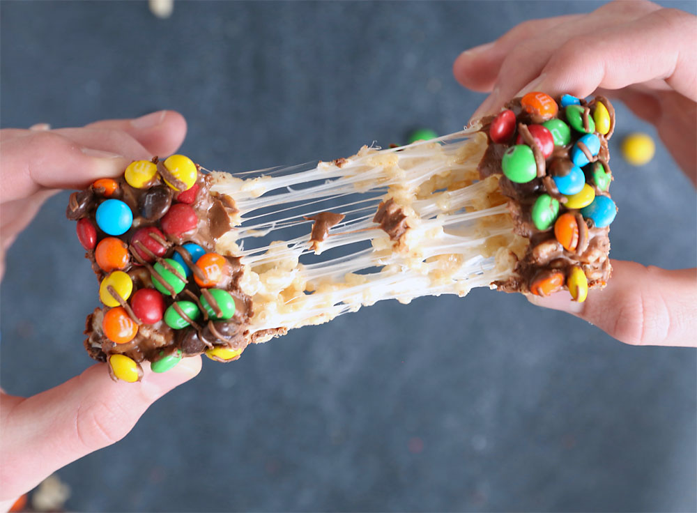 Hands pulling apart an M&M rice krispie treat