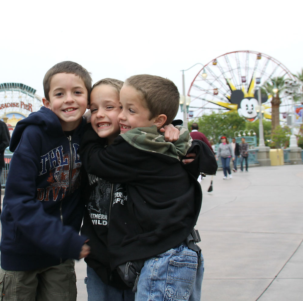 Boys hugging in front of ferris wheel at Disneyland California Adventure