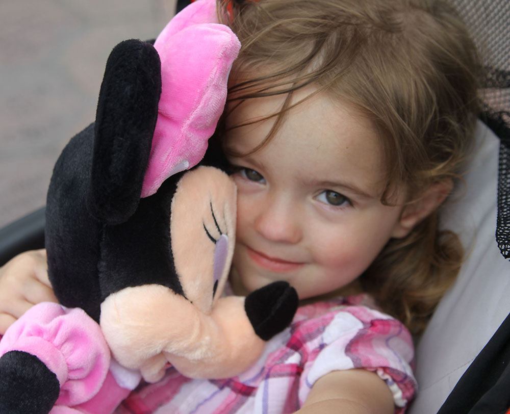 A little girl holding a stuffed animal Minnie Mouse